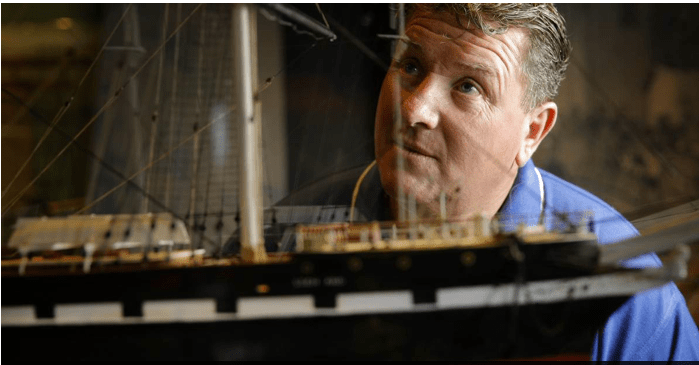 Diving instructor Gary Barclay admires a model of the ill-fated Loch Ard.